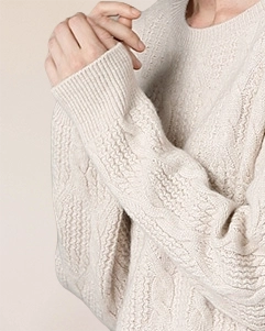 Close-up of VIONIS·XY ivory white cashmere sweater sleeve, ribbed cuff and soft cable knit texture soft Ivory